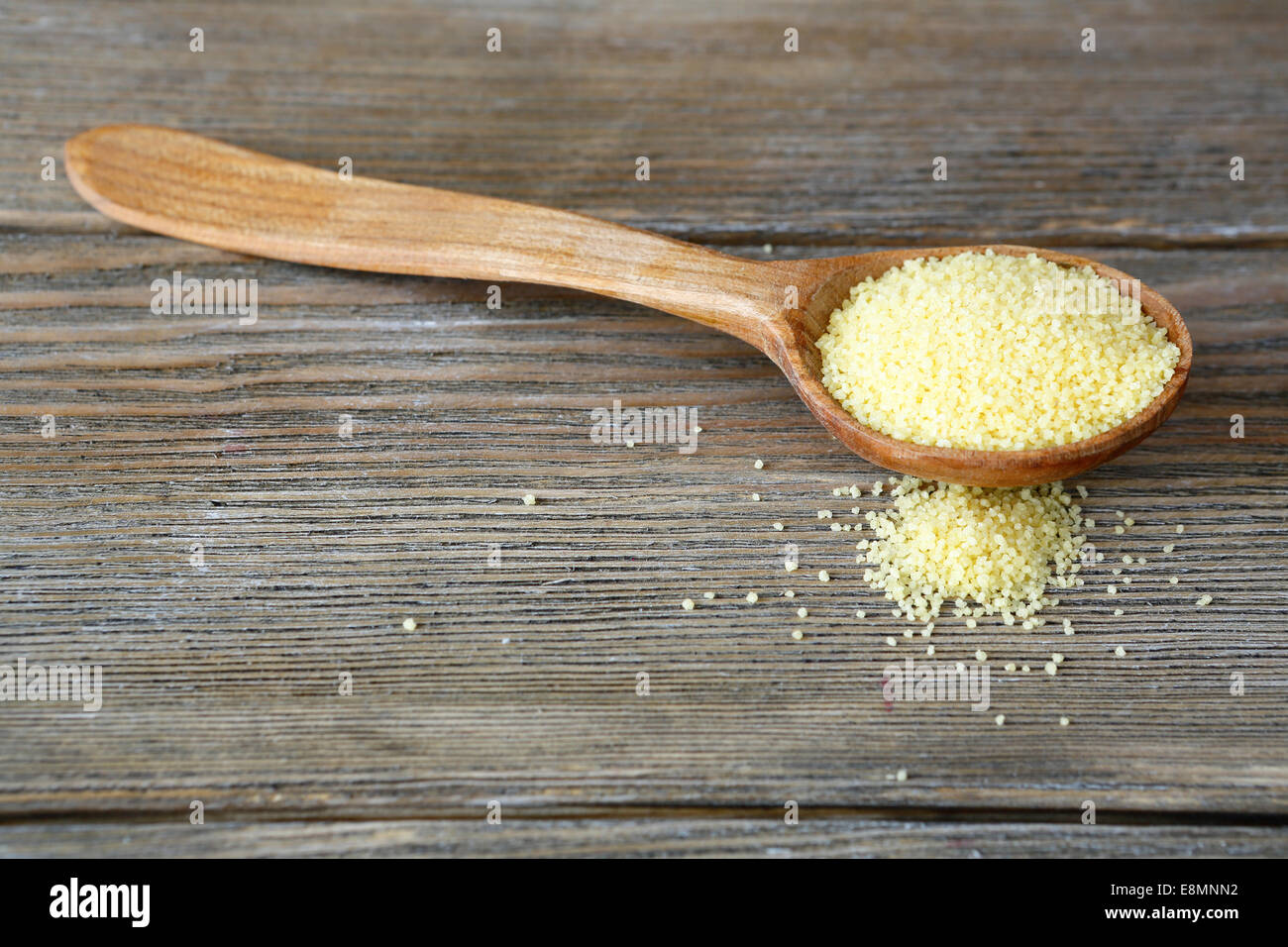 Couscous in a wooden spoon on boards, food close up Stock Photo