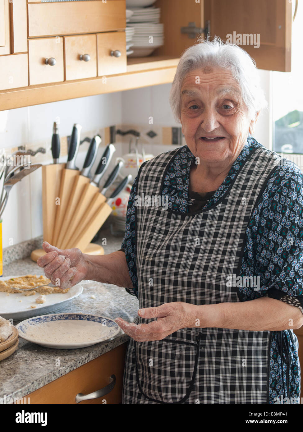 Elderly woman preparing croquettes at home Stock Photo