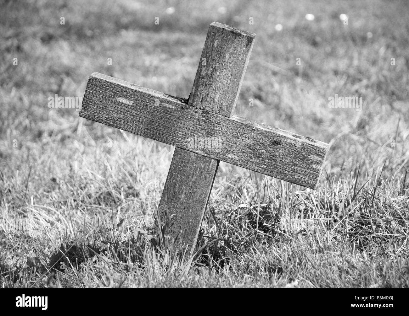 Weathered wooden cross marking a grave - monochrome processing Stock Photo