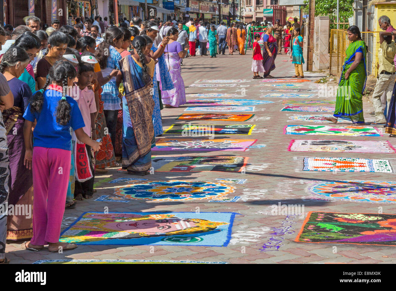 MADURAI INDIAN STREET ART WITH PEOPLE STUDYING THE PICTURES AND TAKING PHOTOGRAPHS ON THEIR MOBILE PHONES Stock Photo