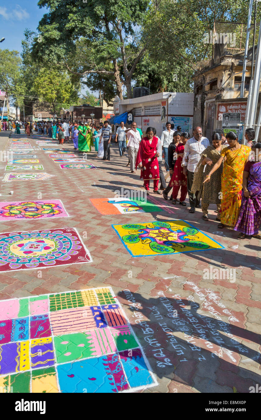 INDIAN STREET ART IN MADURAI PEOPLE STUDYING THE PICTURES ON THE PAVEMENT Stock Photo