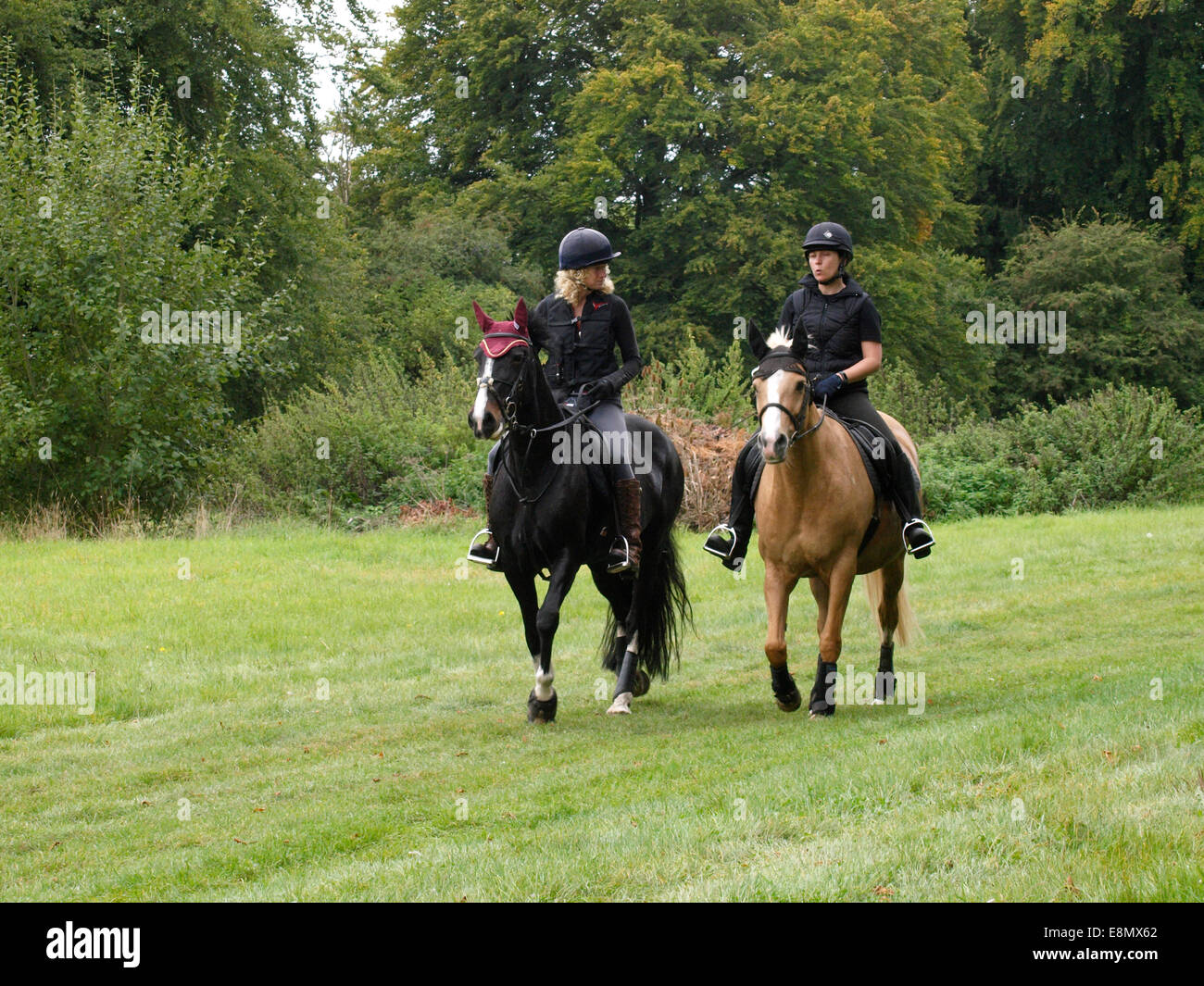 Two women horse riding together, Chettle, Dorset, UK Stock Photo