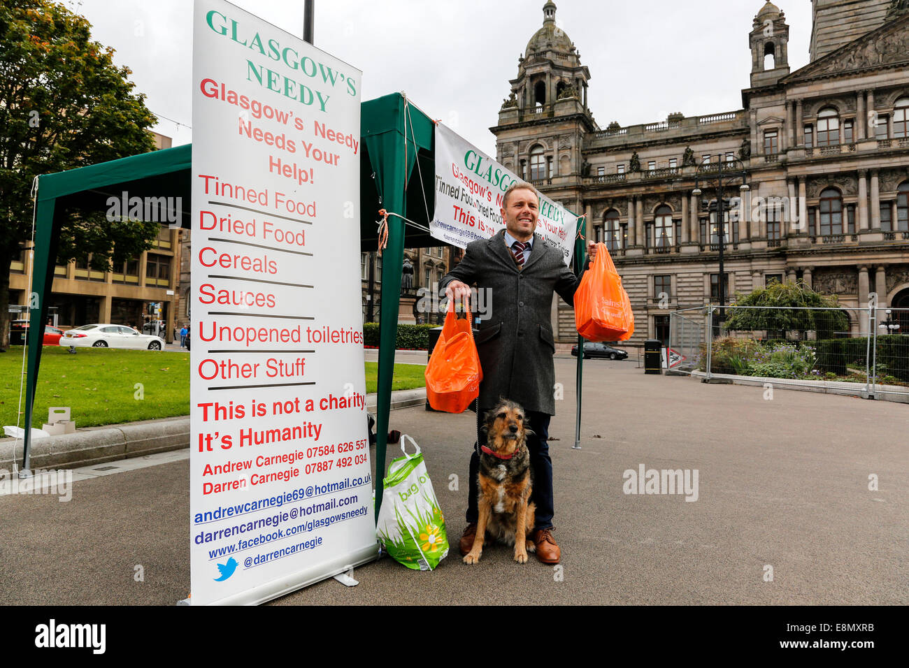 Glasgow, Scotland. 11th Oct, 2014. Andrew Carnegie, aged 45, from Tollcross in Glasgow, who set up the Foodbank charity 'Glasgow's Needy' set up a stall in George Square, Glasgow city centre, outside the City Chambers, with the intention of collecting contributions and also drawing attention to social inequality and the needs of the poor. Several passers- by contributed to his charity by handing in bags of food, including Colin Boyd, aged 38. Company Director from Kilwinning. Credit:  Findlay/Alamy Live News Stock Photo