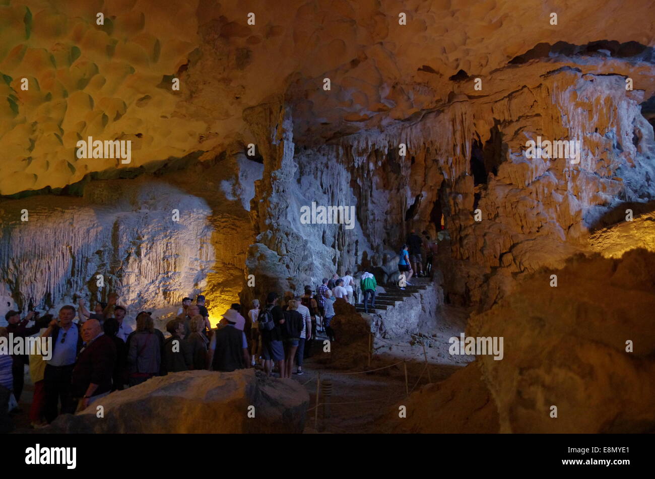 People walking through a cave in Halong Bay Stock Photo