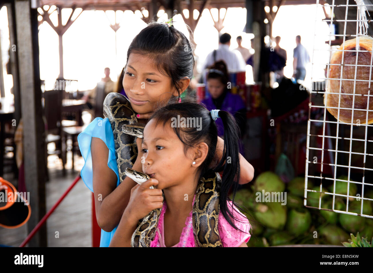Tonle Sap Lake, floating restaurant,, two little girls caressiing pythons Stock Photo