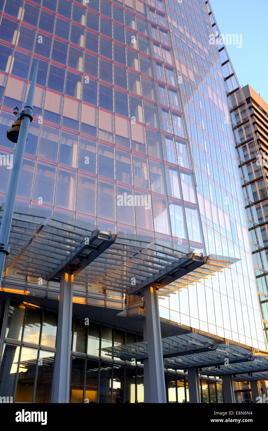 The Shard building in London reflects the pink sunset golden hour glow against a blue sky at dusk Stock Photo