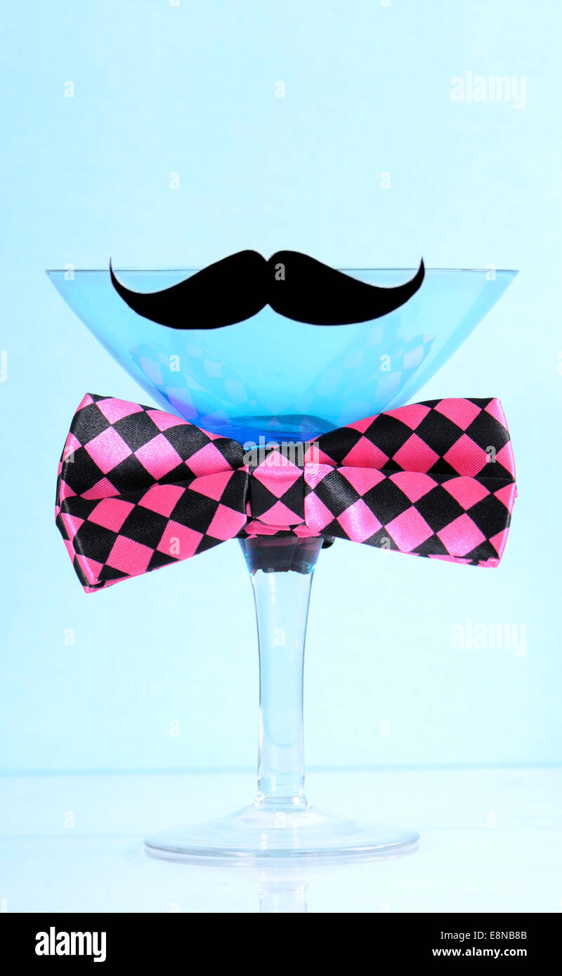 Fund raising for mens health awareness charity with mustache and bow tie on blue martini cocktail glass on blue background. Stock Photo