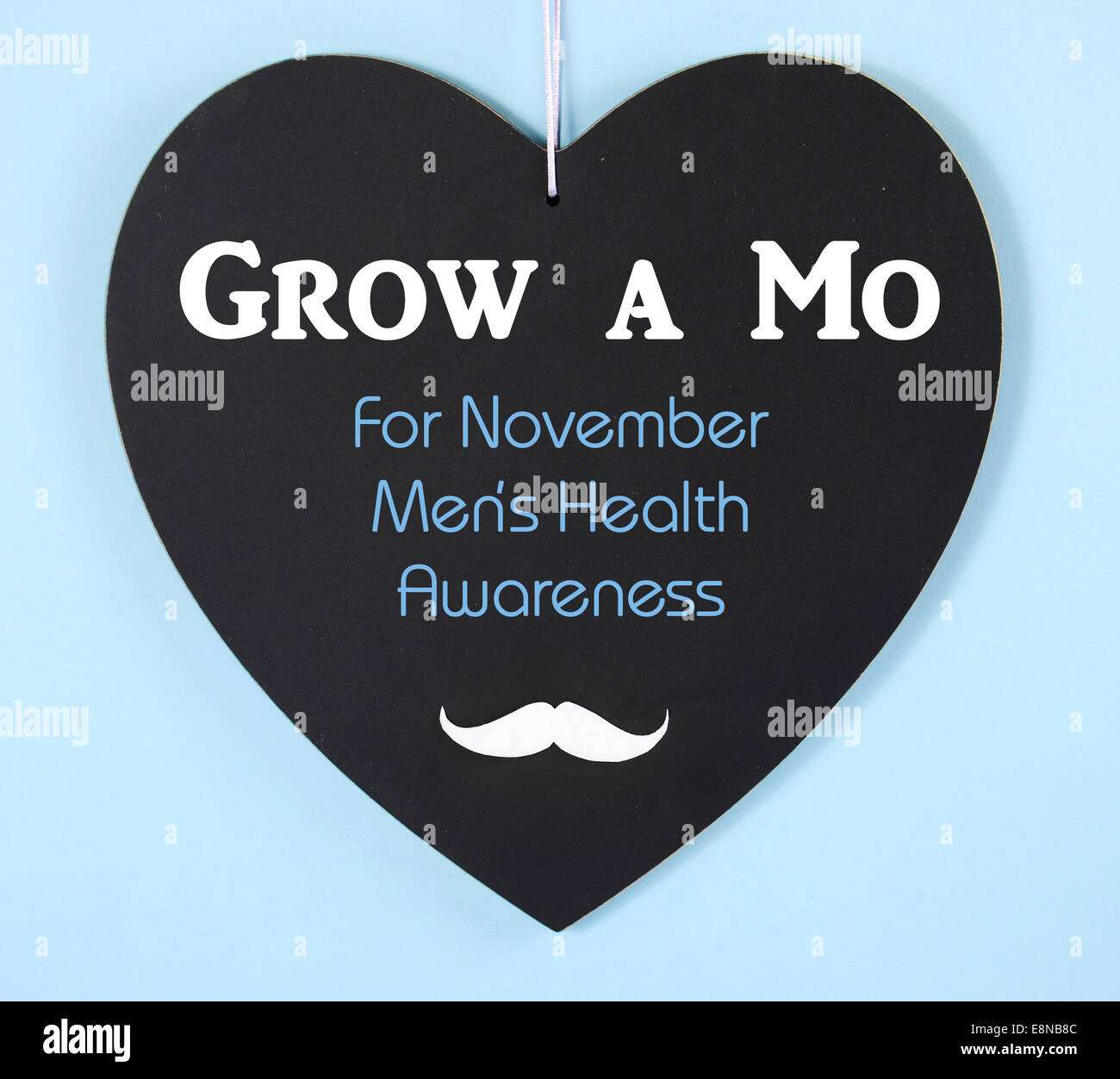 Grow a Moustache message on heart shaped blackboard for November Mens Health Issues Awareness Stock Photo