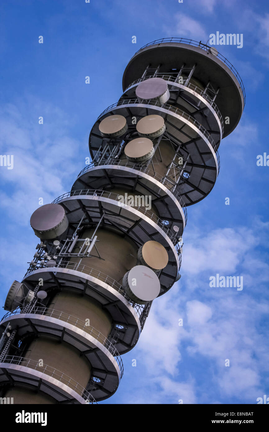 Communication tower with antenna, dish and aerials with a blue sky. Sending and receiving mobile cell phone, radio and tv signal Stock Photo