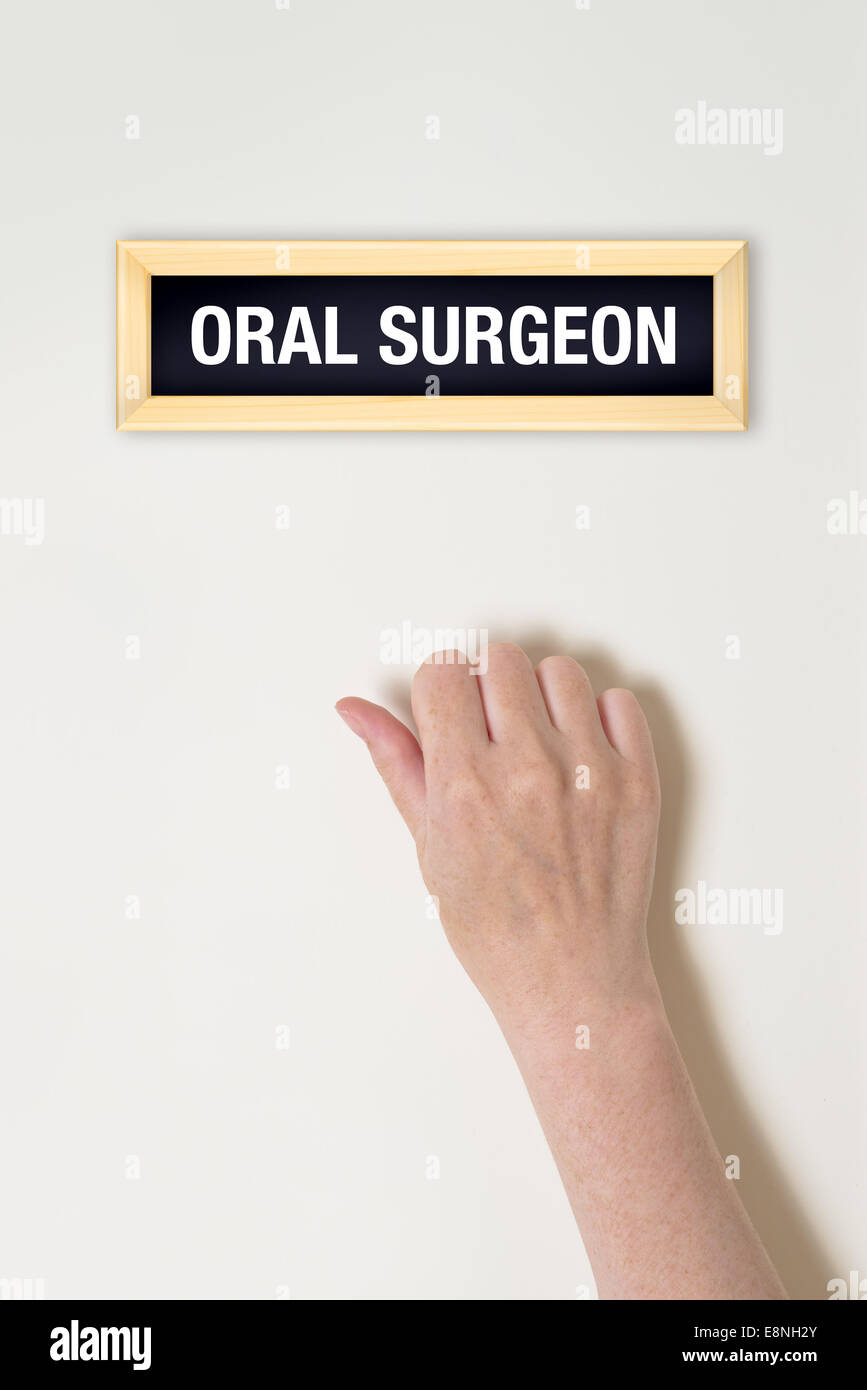 Female hand is knocking on Oral surgeon door for a medical exam Stock Photo