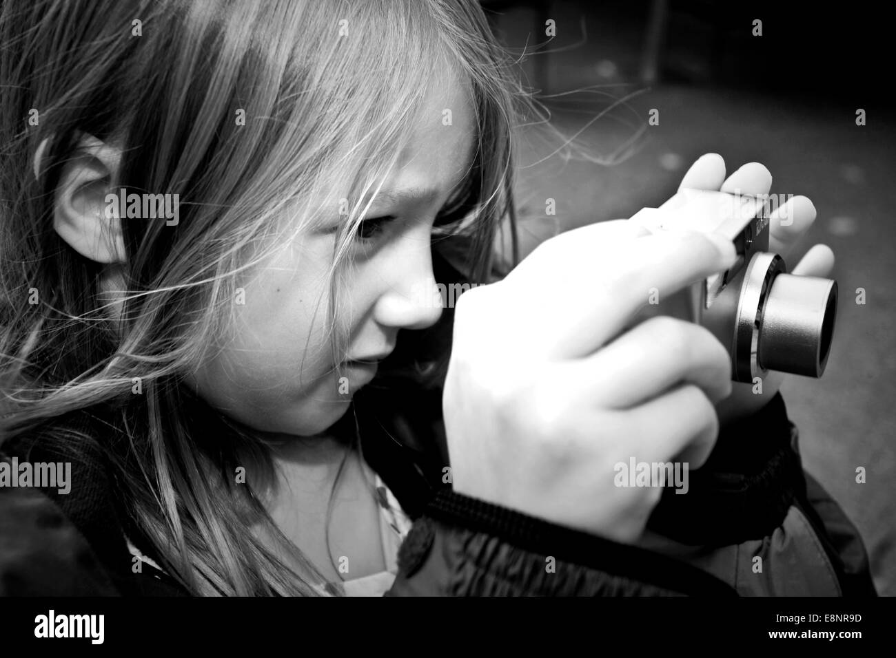 A young girl takes a photograph with a digital camera Stock Photo