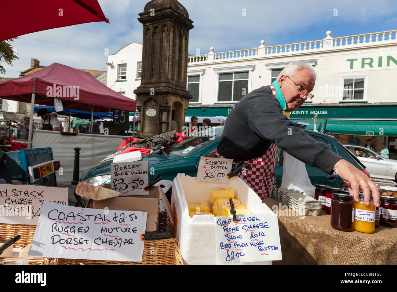 Man selling jams and dairy products from a market stall in Axminster, Devon. Stock Photo