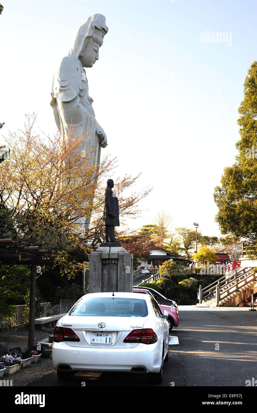 Visitor's cars parked near the statue of the Buddhist goddess Kannon which overlooks the city of