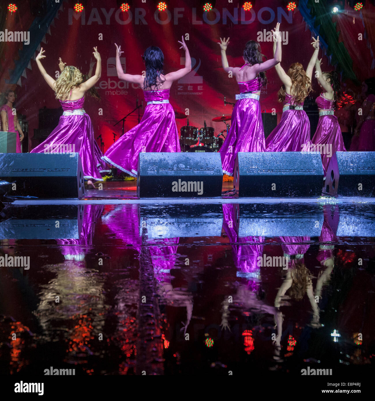 London, UK, 12th October 2014.  Thousands gathered in the rain in Trafalgar Square to celebrate the annual Diwali Festival and to enjoy Bollywood dances which took place on a soaked stage which created eye-catching reflections.    Credit:  Stephen Chung/Alamy Live News Stock Photo