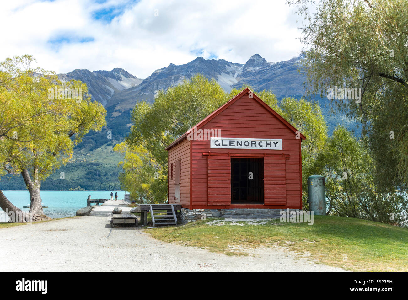 Glenorchy historic boat shed and jetty with a couple, two people, on Lake Wakatipu with The Remarkables, Otago New Zealand Stock Photo