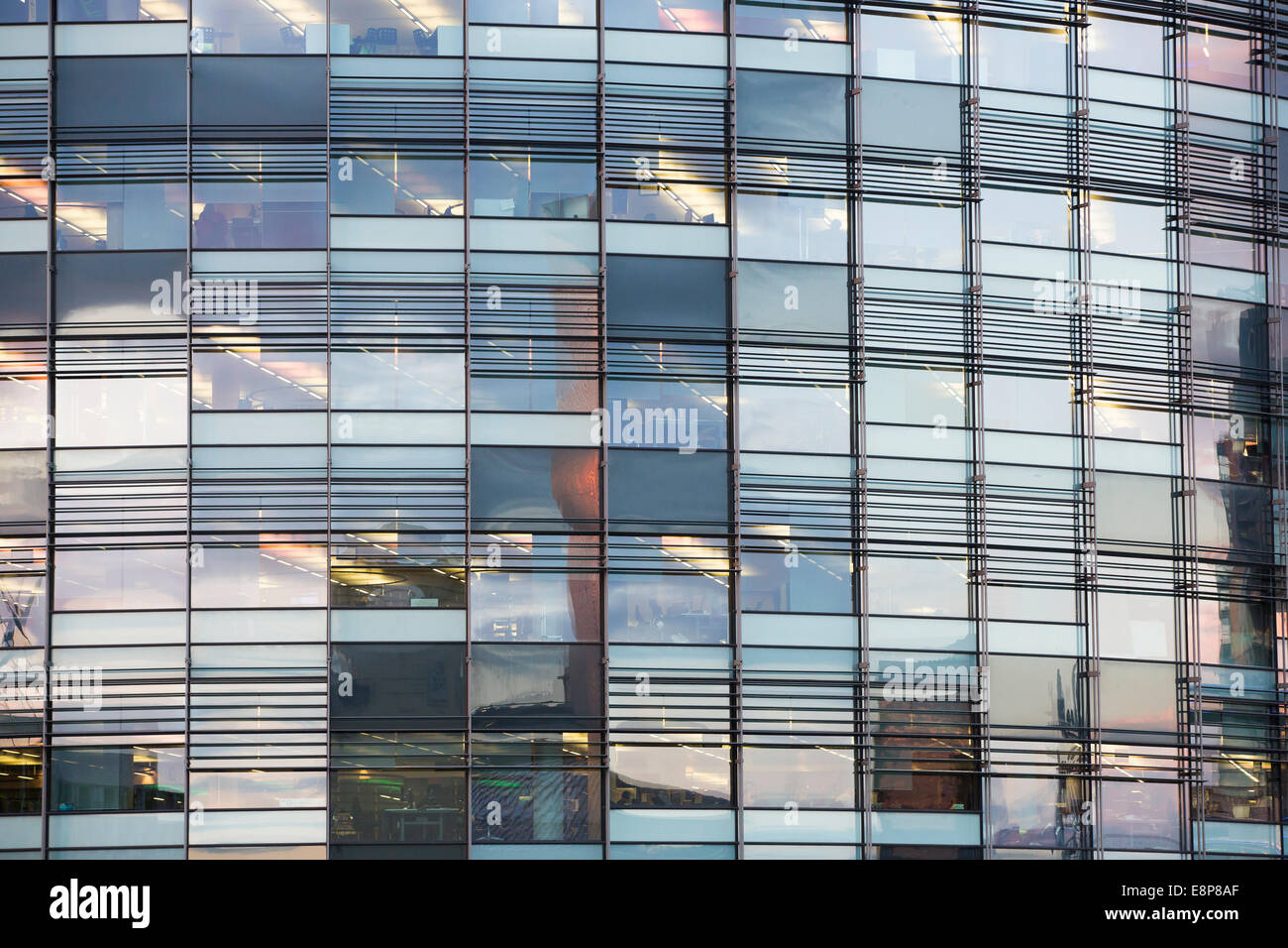 Windows at the offices of the BBC in Salford Quays, Manchester, reflect the setting sun at sunset. Stock Photo