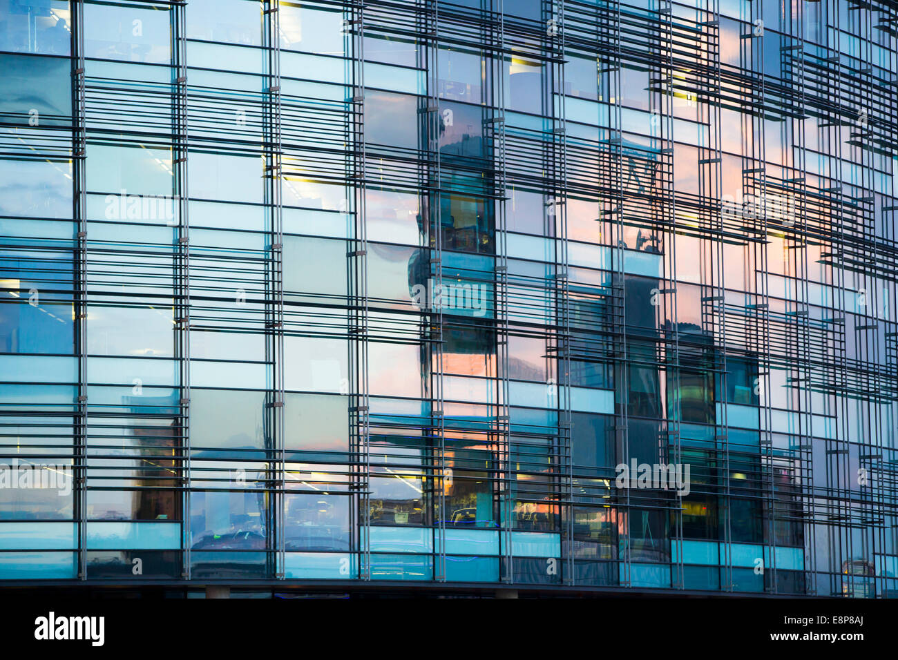 Windows at the offices of the BBC in Salford Quays, Manchester, reflect the setting sun at sunset. Stock Photo