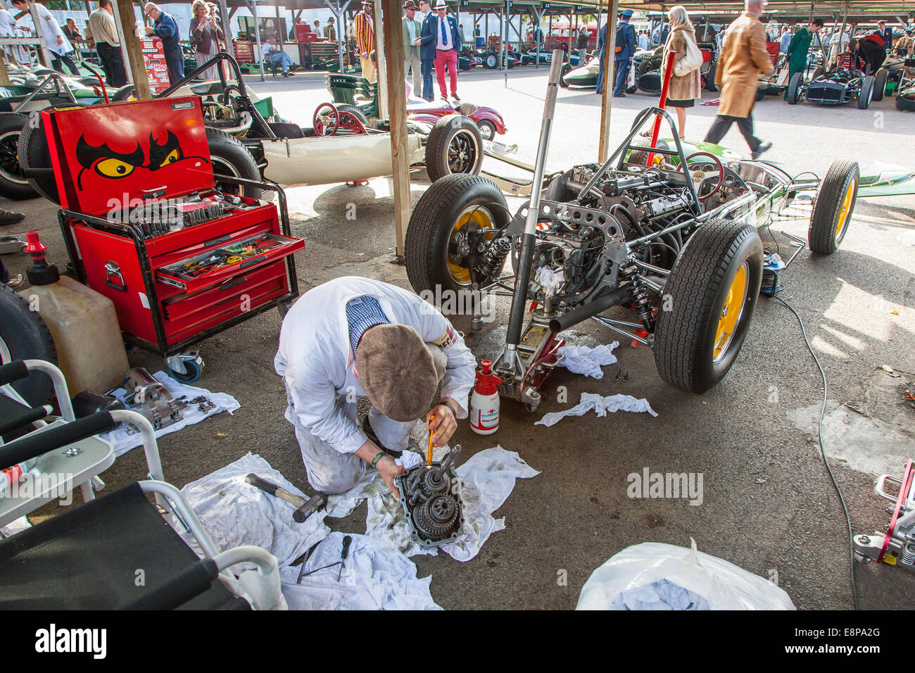 Mechanic working on a classic vintage Lotus racing car gearbox in the paddock at the Goodwood
