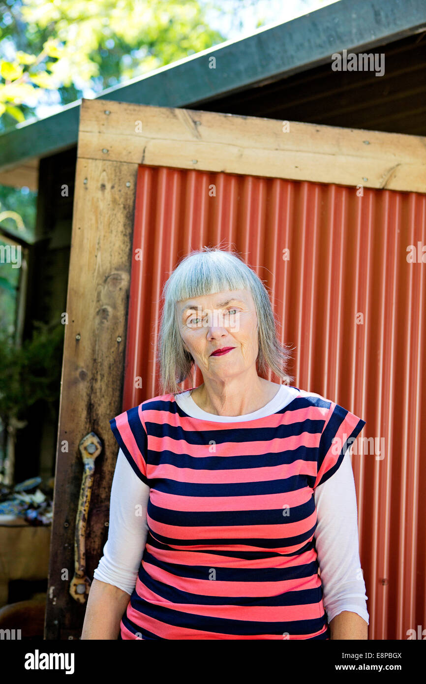 Senior woman standing outside building Stock Photo