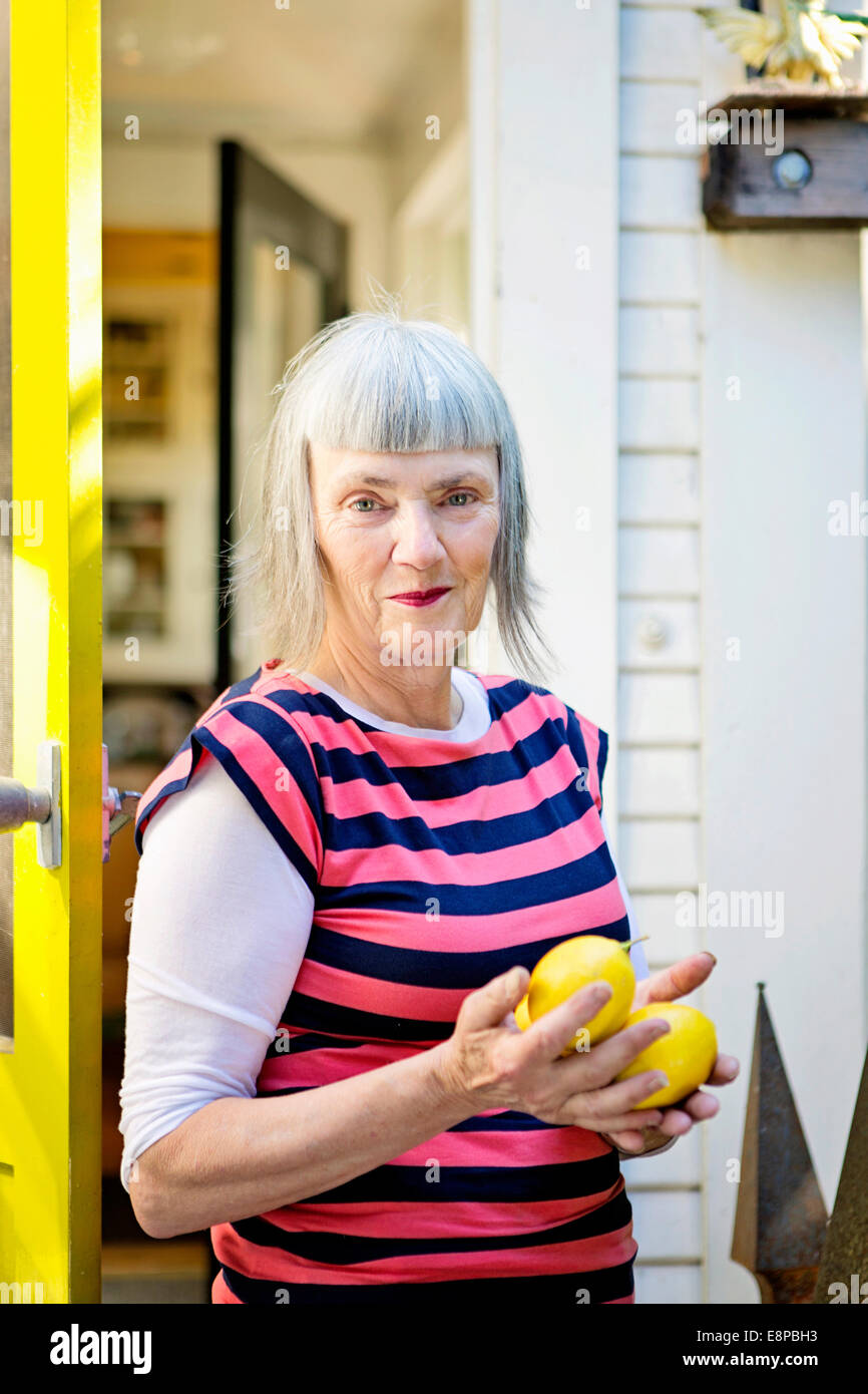 Senior woman holding fresh lemons Stock Photo