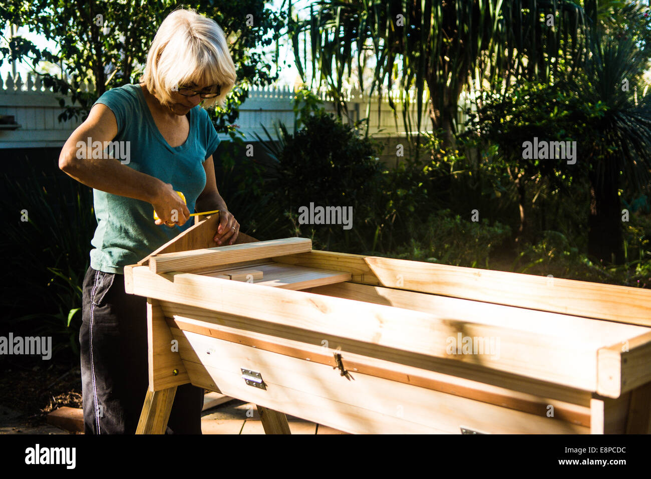 Woman making a top bar beehive, Brisbane, Queensland, Australia Stock