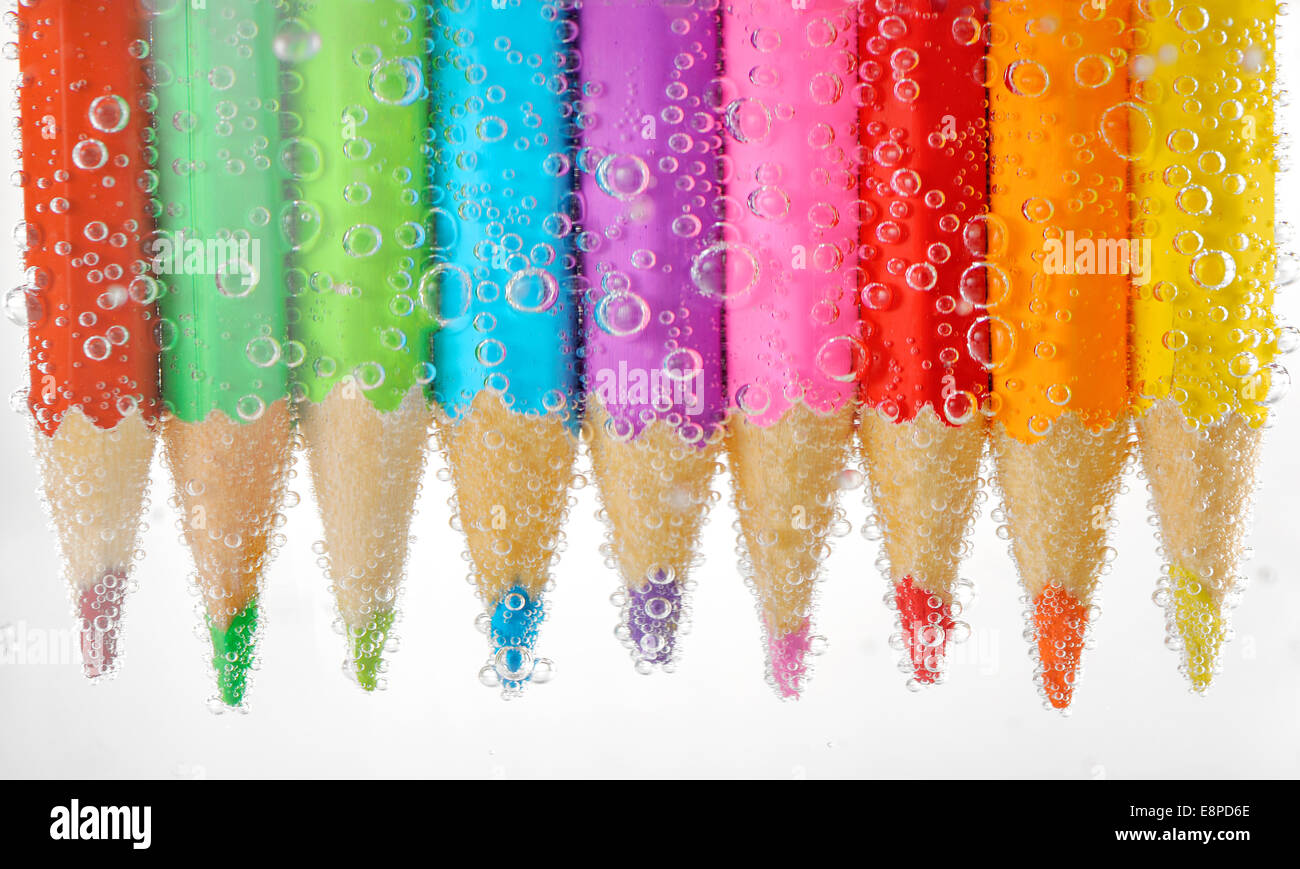 Colorful pencils in water with bubbles, isolated on white Stock Photo