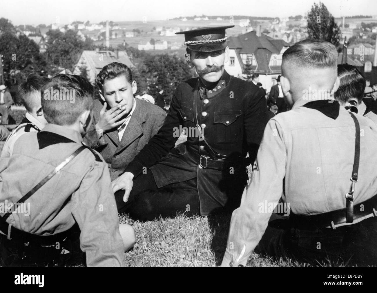 The Nazi propaganda picture shows a Sudetenland police officer who fled from Czechoslovakia speaking with Hitler youth in the run-up to the Munich Agreement in Baerenstein, Germany, September 1938. The original text from a Nazi news report on the back of the picture reads: ' Sudeten Germans fleeing from Czech terror. This policeman fled from Weipert with other Sudeten Germans wearing a Czech police uniform tells his shocking experiences to these Hitler Youth (in Baerenstein). Fotoarchiv für Zeitgeschichtee - NO WIRE SERVICE Stock Photo