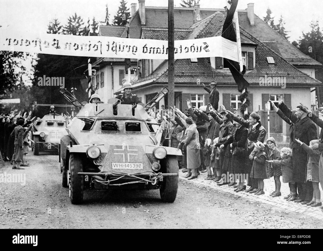 The Nazi propaganda picture shows the reception for German soldiers as they cross under a banner reading 'Sudetenland greets its liberators' at the border at Wildenau-Asch, Sudetenland (today Czech Republic) in October 1938. The original text from the Nazi news service on the back of the picture reads: 'The Fuhrer in the liberated Sudetenland. Motorized groups pass the border near Wildenau to the cheers of the Sudeten population.' Fotoarchiv für Zeitgeschichtee - NO WIRE SERVICE Stock Photo