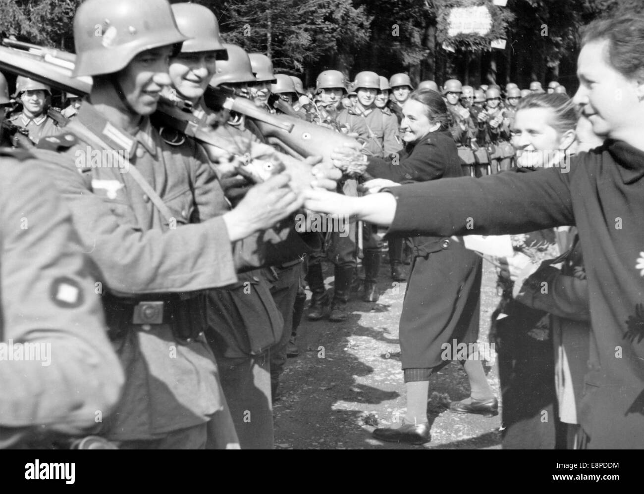 The Nazi propaganda picture shows women welcoming German troops in Braunau, Sudetenland (today Broumov, Czech Republic) in October 1938. The original text from the Nazi news service on the back of the picture reads: 'The arrival of German troops in Division V. No German soldier marches without flowers into the liberated Sudetenland: Sudeten German women decorate the soldiers marching through Braunau with flowers.' Fotoarchiv für Zeitgeschichtee - NO WIRE SERVICE Stock Photo