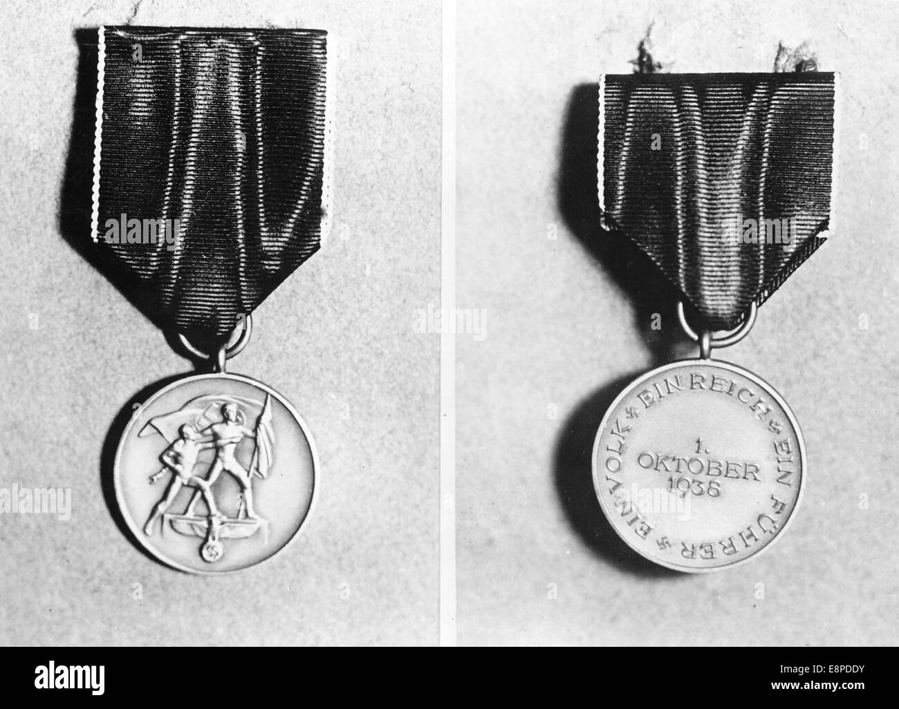 The Nazi propaganda picture shows the medal from October 1938 to commemorate the 'return of the Sudetenland' in November, 1938, location unknown. The original text from a Nazi news report on the back of the picture reads: 'A medal to commemorate the October 1, 1938. Thanks for the return of the Sudetenland. The Fuhrer and Reich Chancellor founded the 'Medal to Commemorate October 1, 1938' on 18 October 1938 as an expression of recognition and thanks for the services towards the reunification of the Sudeten territories with the German Reich. Out picture shows: the front (L) and back sides of th Stock Photo
