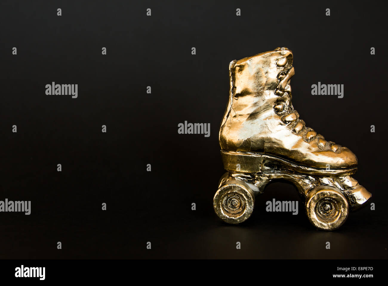 golden roller skate with high heel isolated against black background Stock Photo Alamy