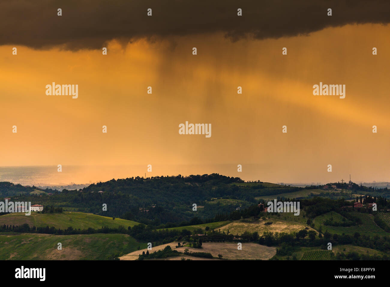 Rainy day atmosphere with orange clouds of rain flowing over Emilia