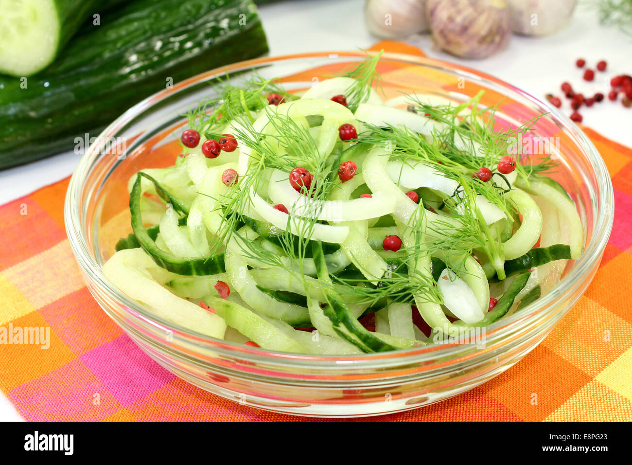 a bowl of cucumber salad with dill and red pepper berries Stock Photo