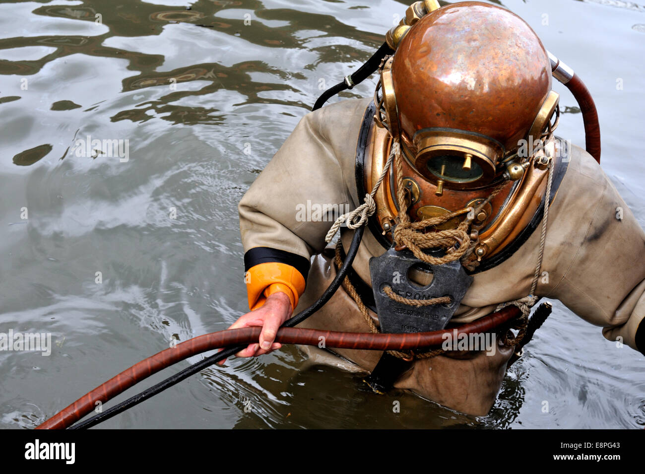 Hard hat diver entering / leaving water holding surface supplied airline. Bristol City Docks flouting harbour Stock Photo