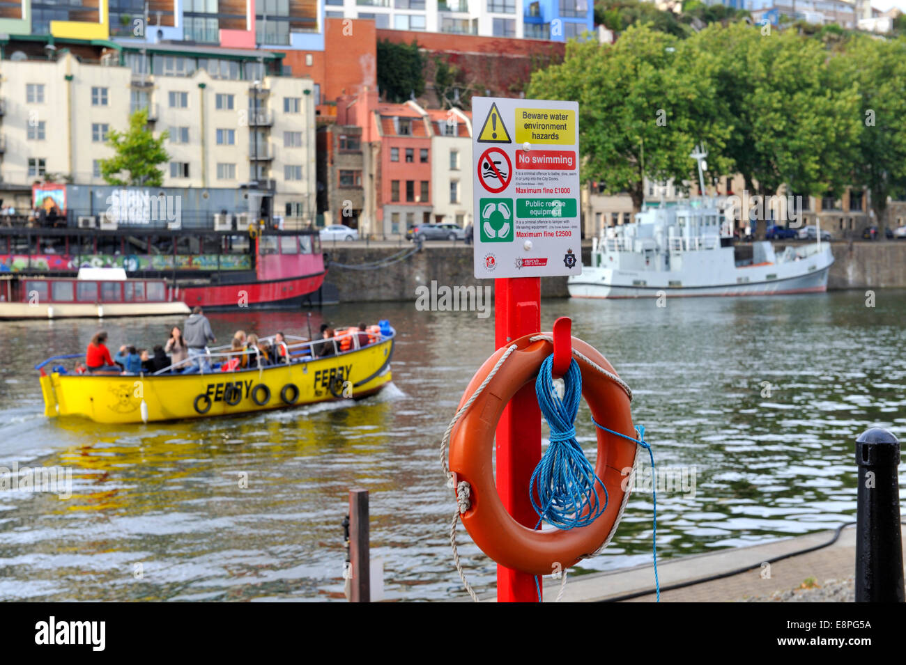 Lifebuoy and throwing rope with warning sign quayside Bristol City Docks flouting harbour Stock Photo