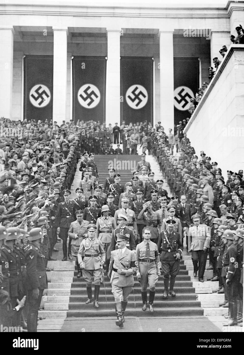 Nuremberg Rally 1936 in Nuremberg, Germany - Adolf Hitler walks down the stairs of the grandstand to accept the march-past of the Nazi army (Wehrmacht) on Zeppelin Field at the Nazi party rally grounds. Behind Hitler to the right: Reich Minister Rudolf Hess. (Flaws in quality due to the historic picture copy) Fotoarchiv für Zeitgeschichtee - NO WIRE SERVICE - Stock Photo