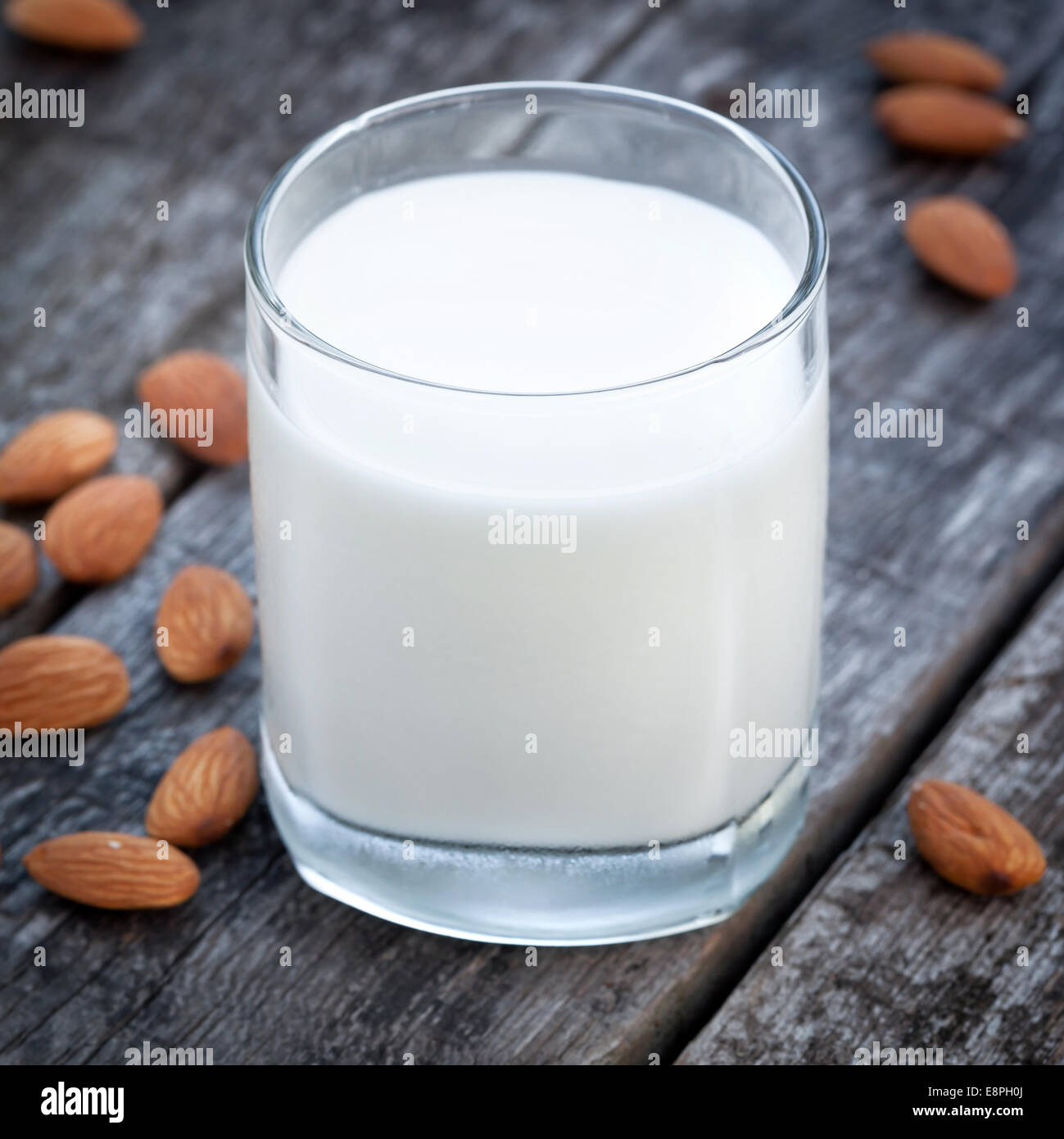 Almond milk, nuts and glass of tasty milk on old wooden table Stock Photo