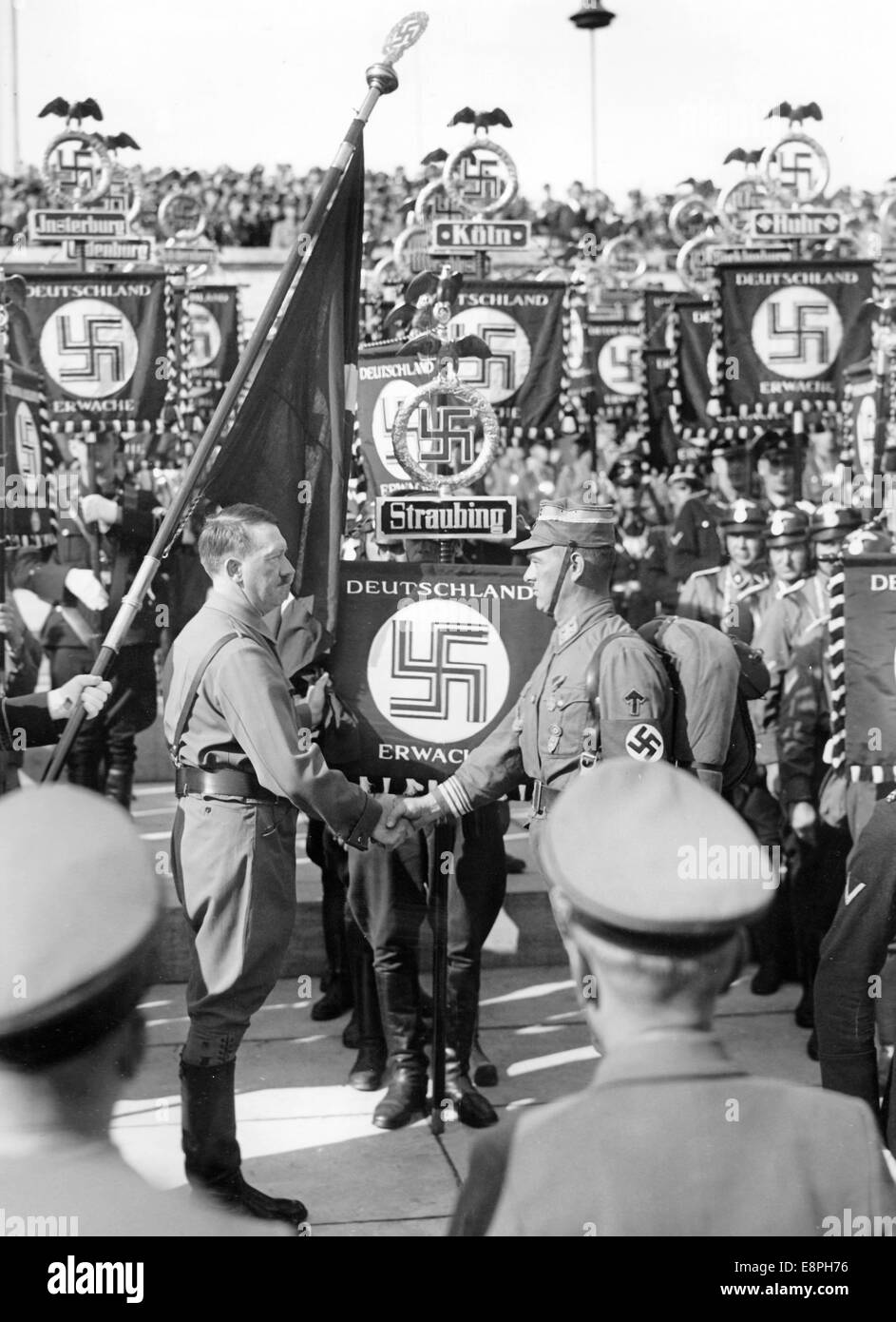 Nuremberg Rally 1936 in Nuremberg, Germany - Adolf Hitler consecrates the new standards with the 'Blood Flag' during the roll call of the Sturmtruppe (SA), Schutzstaffel (SS) and National Socialist Motor Corps (NSKK). New standards of SA and SS were 'consecrated' by touching them to the 'Blood Flag', which supposedly was carried in the failed Beer Hall Putsch. (Flaws in quality due to the historic picture copy) Fotoarchiv für Zeitgeschichtee - NO WIRE SERVICE - Stock Photo