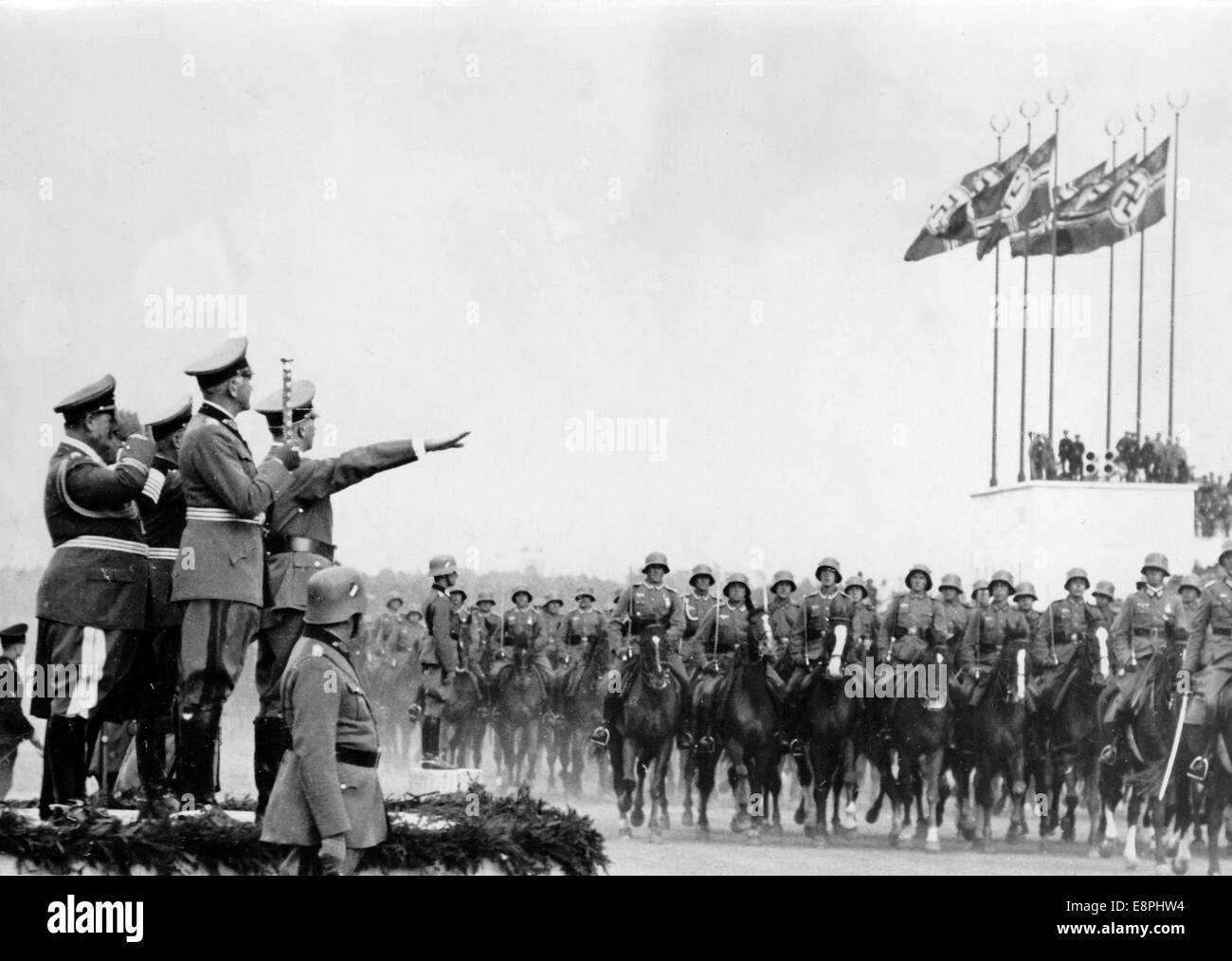 Nuremberg Rally 1937 in Nuremberg, Germany - Nazi party rally grounds - Demonstration by the Nazi armed forces (Wehrmacht) on Zeppelin Field, here march-past of the cavalry in front of Adolf Hitler (right, on the podium), Minister of War Werner von Blomberg (second from right, on the podium) and Colonel General Hermann Goering (left, on the podium). (Flaws in quality due to the historic picture copy) Fotoarchiv für Zeitgeschichtee - NO WIRE SERVICE - Stock Photo