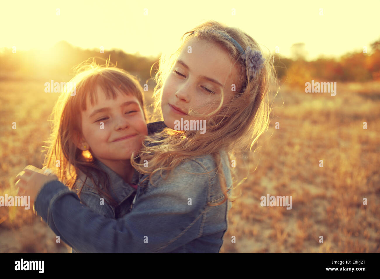 two girls running around the sunny field Stock Photo - Alamy