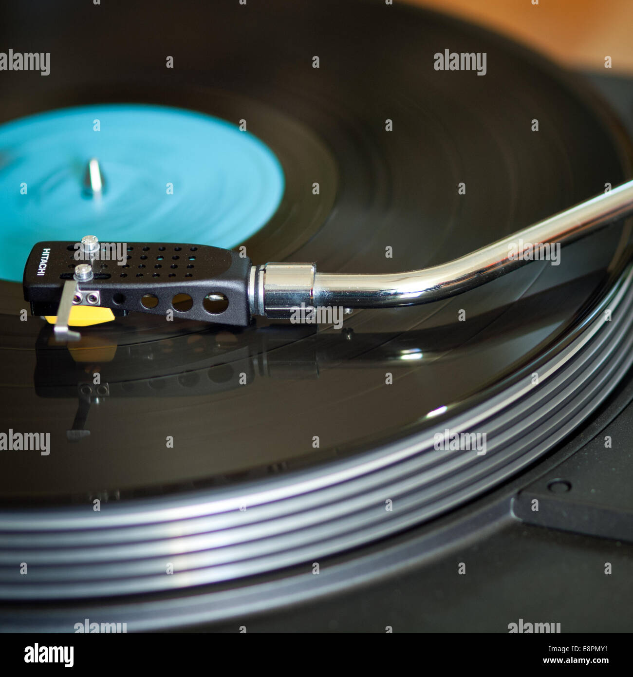 A vinyl record spins on a vintage, late 1970's Hitachi HT-350 turntable record player. Stock Photo