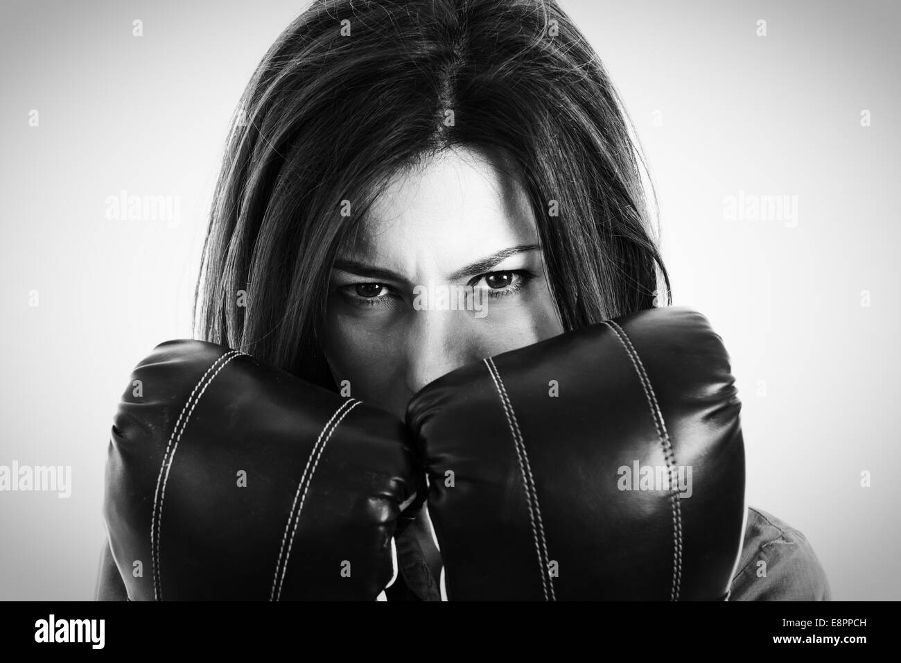 Closeup portrait of a determined female boxer. Confident modern business woman with boxing gloves in isolated over white backgro Stock Photo