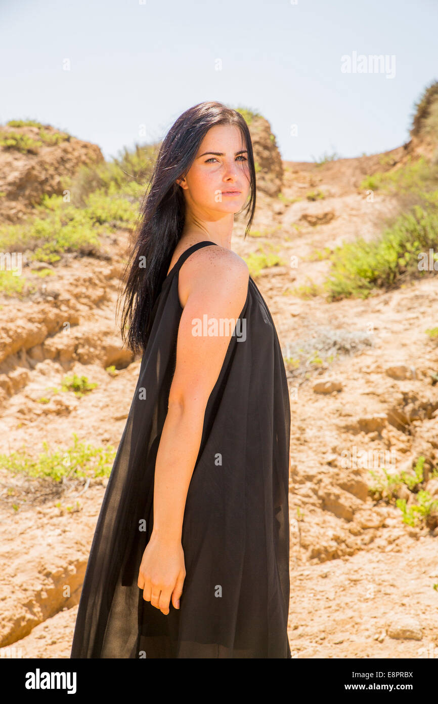 Feminine woman in elegant black dress outdoors Stock Photo