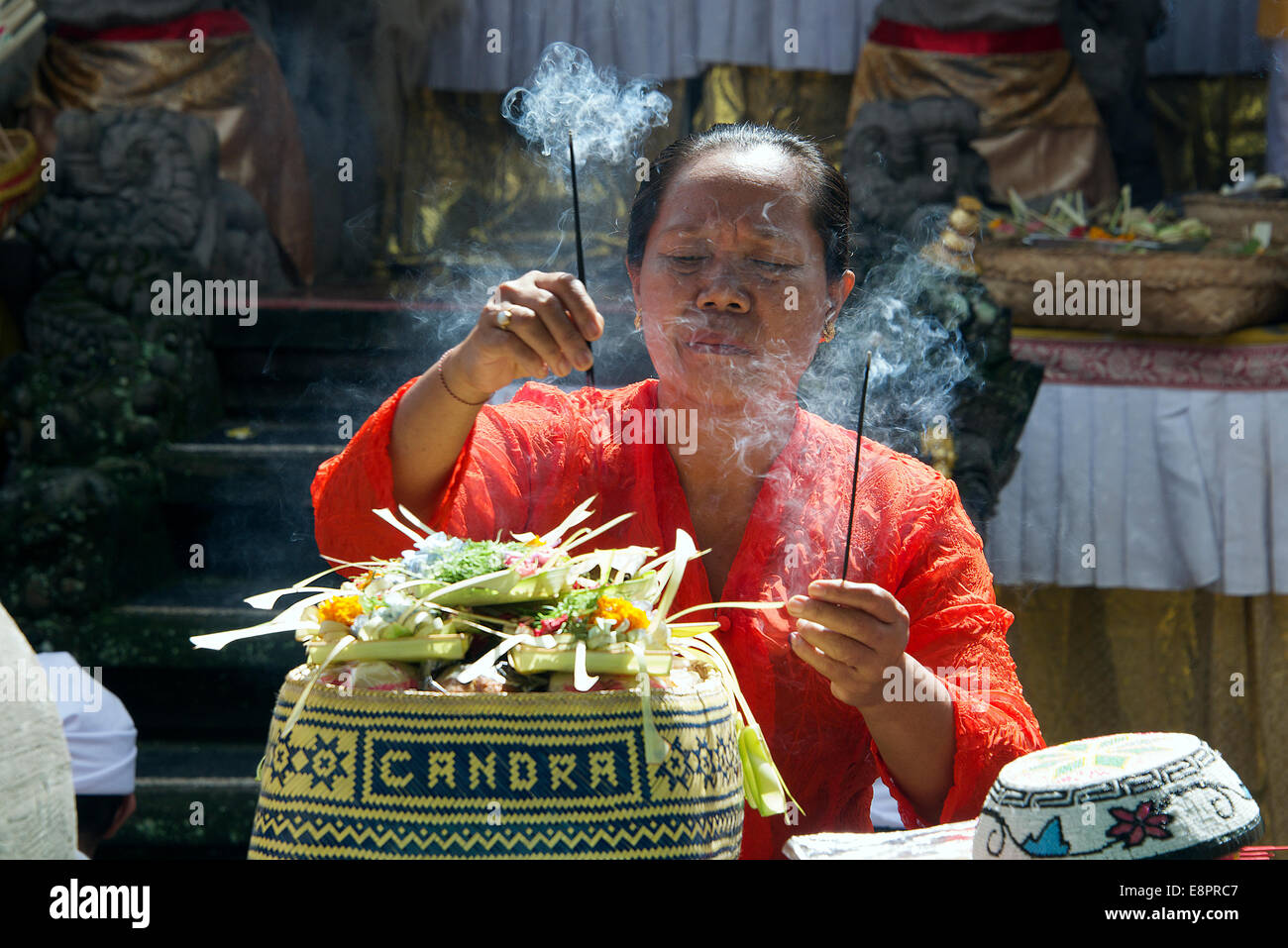 Balinese woman preparing offerings in temple for ceremony Ubud Bali Indonesia Stock Photo