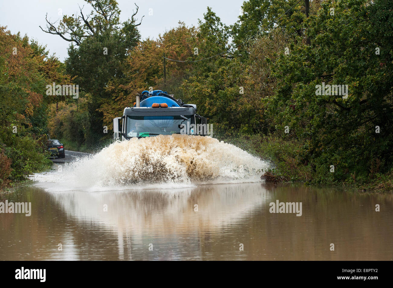 Essex, UK. 13th October, 2014.  Vehicles driving through flooded roads near Buttsbury in Essex after overnight torrential rain. Credit:  Gordon Scammell/Alamy Live News Stock Photo