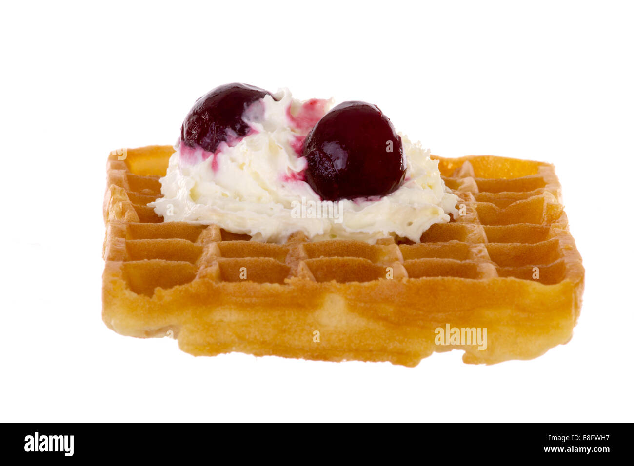 Cherries and whipped cream on freshly baked waffle Stock Photo
