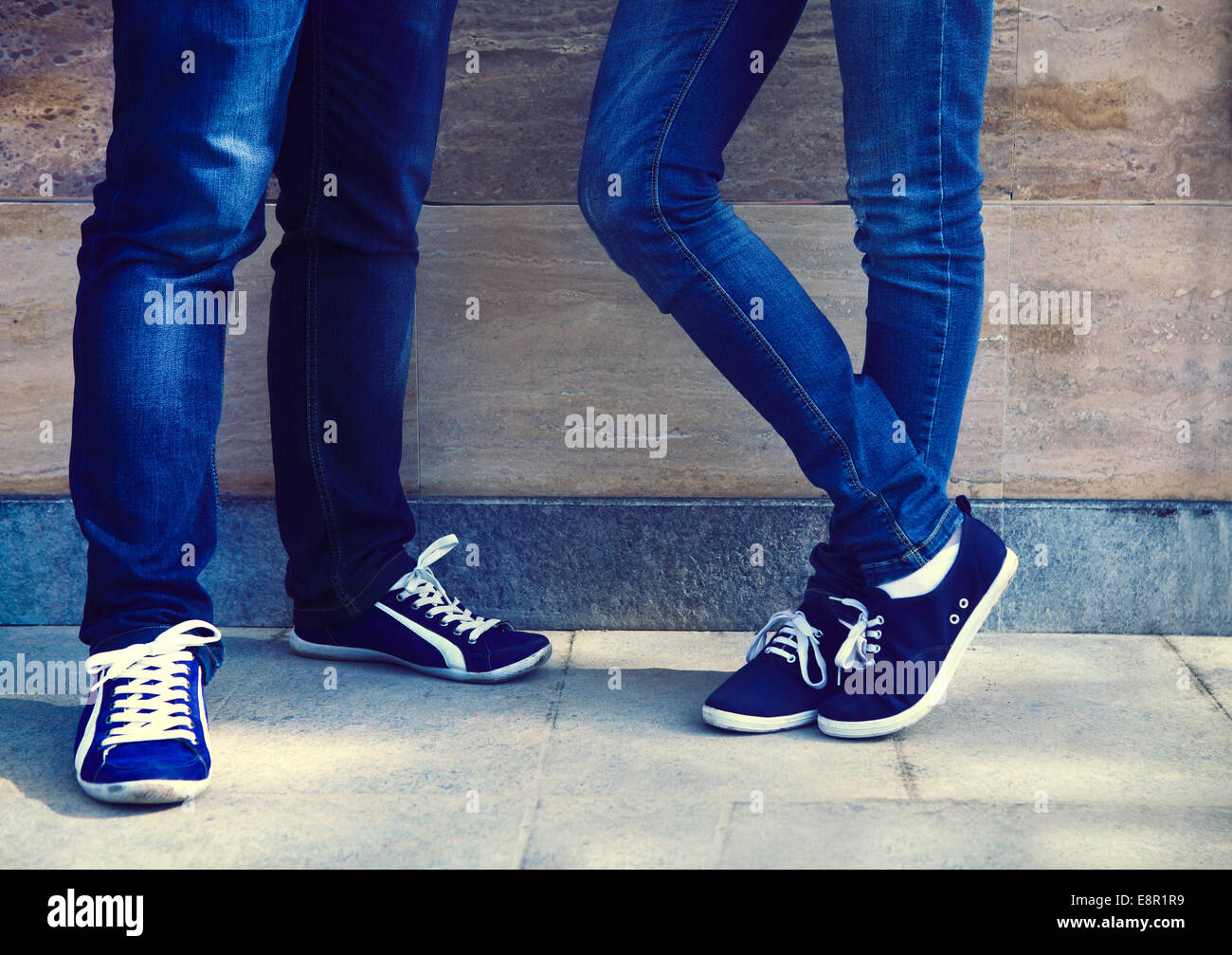 A pair of vintage looking, athletic shoes and skinny jeans on the couple  near the wall. Close up Stock Photo - Alamy