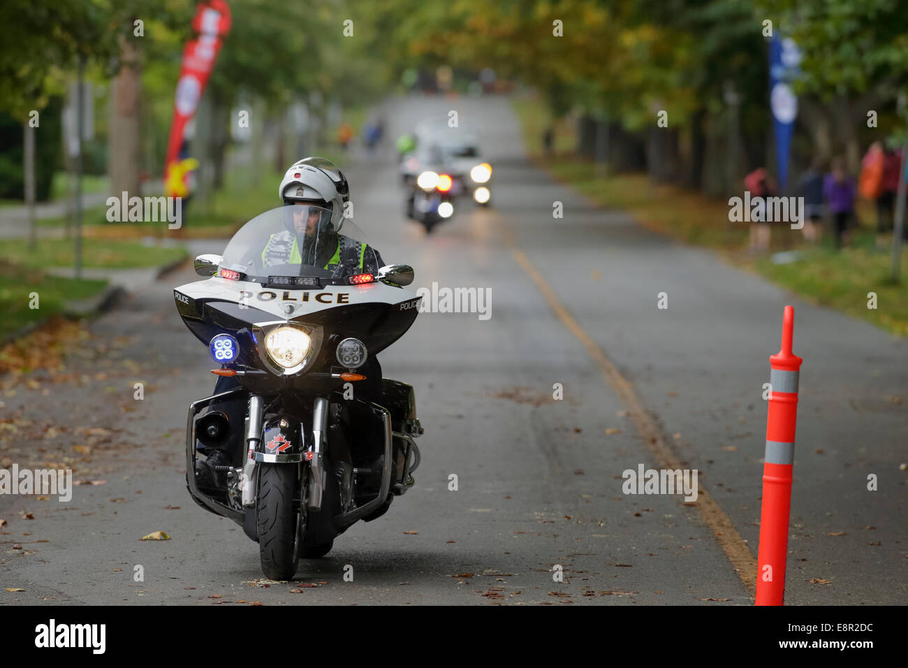 Policeman on motorcycle leading 2014 Royal Victoria Goodlife marathon raceVictoria, British