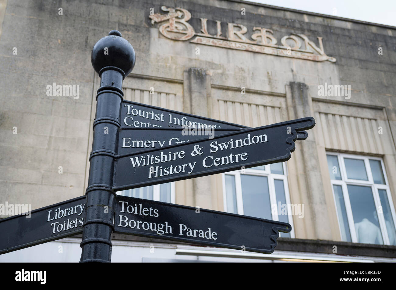 Tourist information sign post in Chippenham Wiltshire UK with remnant of store sign for the former Burton the tailor Stock Photo