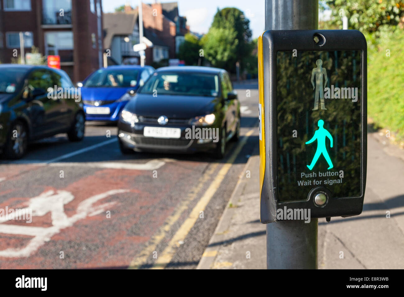 Green man sign illuminated at a puffin crossing while cars wait, Nottinghamshire, England, UK Stock Photo